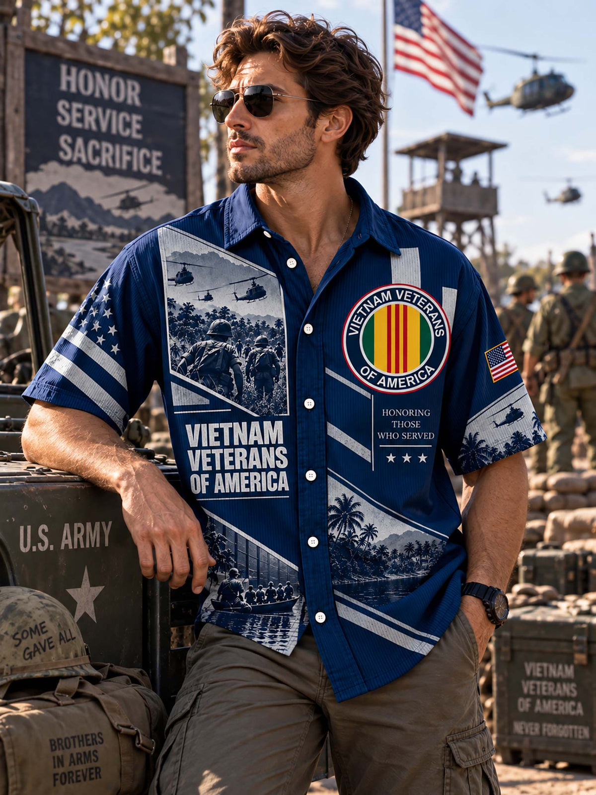 A man wearing a blue short-sleeve button-up shirt with Vietnam Veterans of America graphics, posing outdoors next to military equipment and crates.