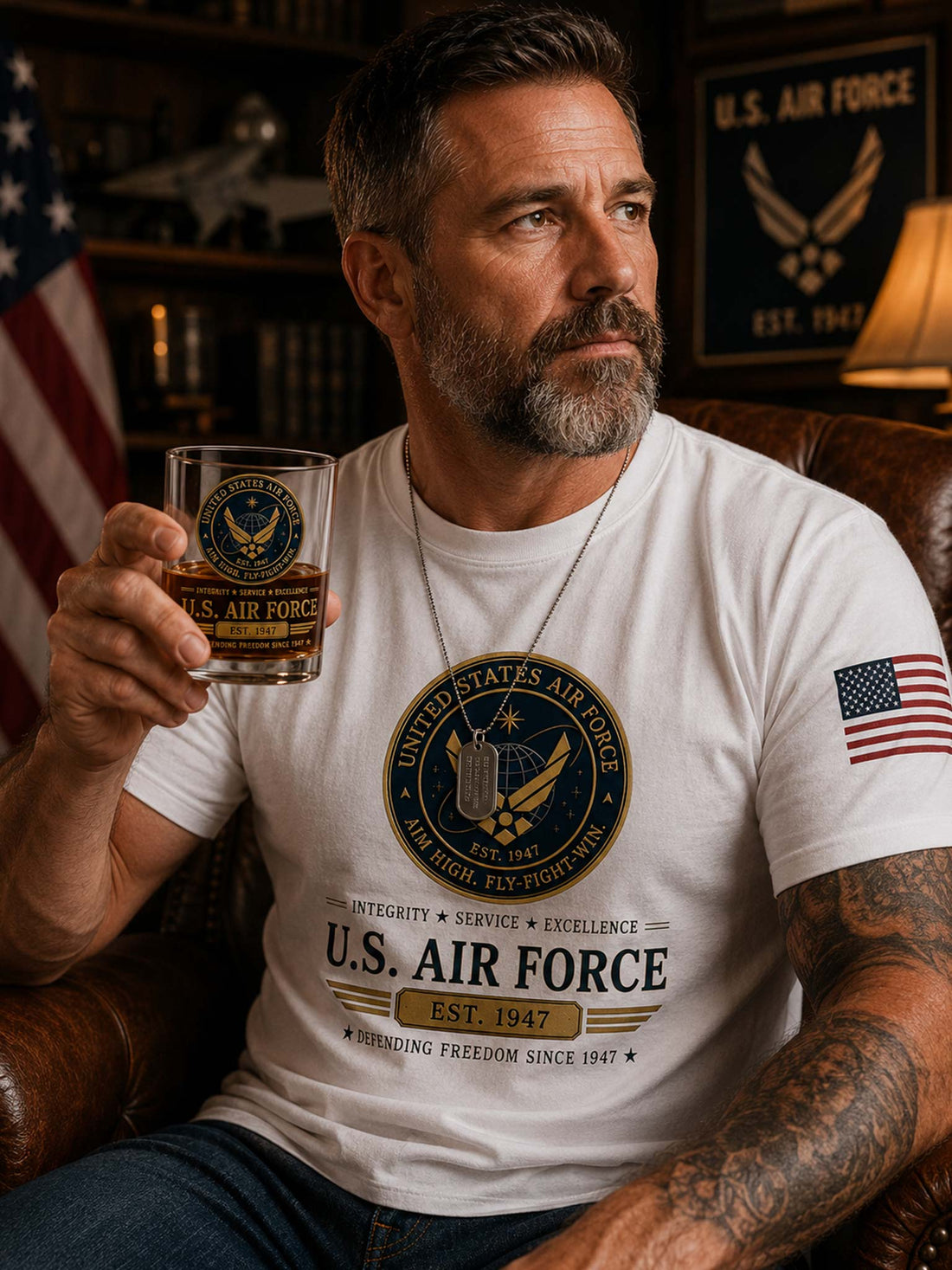 A clear rocks glass filled with amber whiskey, featuring a large gold and navy United States Air Force emblem and 'U.S.