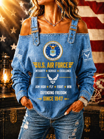 A woman wearing a blue off-the-shoulder denim long-sleeve top with a large U.S.