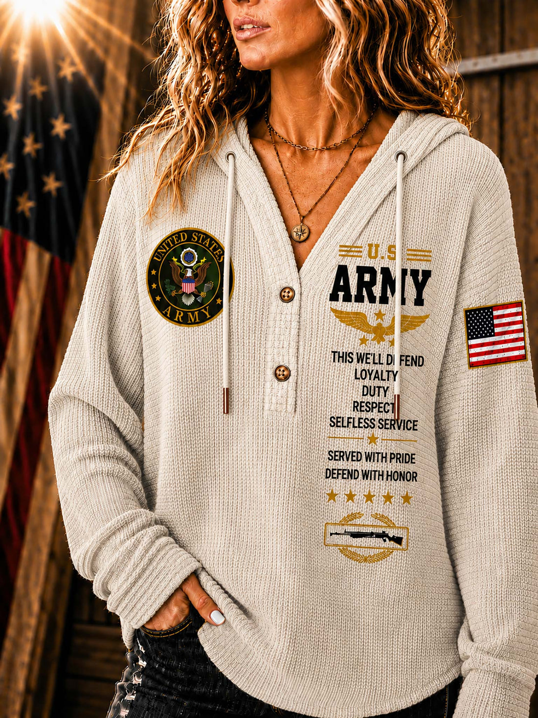 A woman wearing a light beige waffle-knit hoodie sweatshirt with military-themed graphics, including 'U.S.