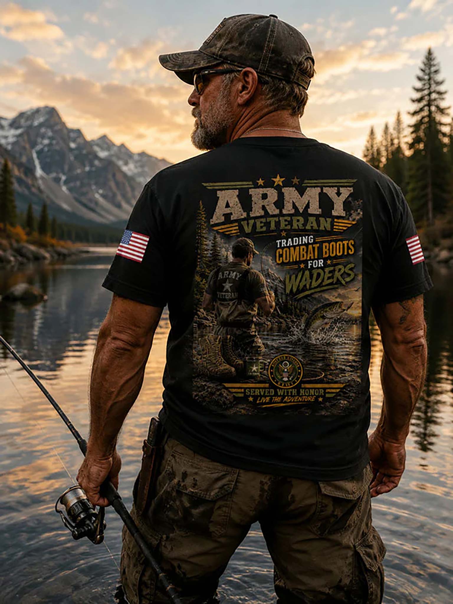 A man stands by a lake at sunset wearing a black graphic T-shirt with a large military-themed back print reading 'ARMY VETERAN' and 'Trading Combat Boots for Waders,' along with camouflage pants and a cap.