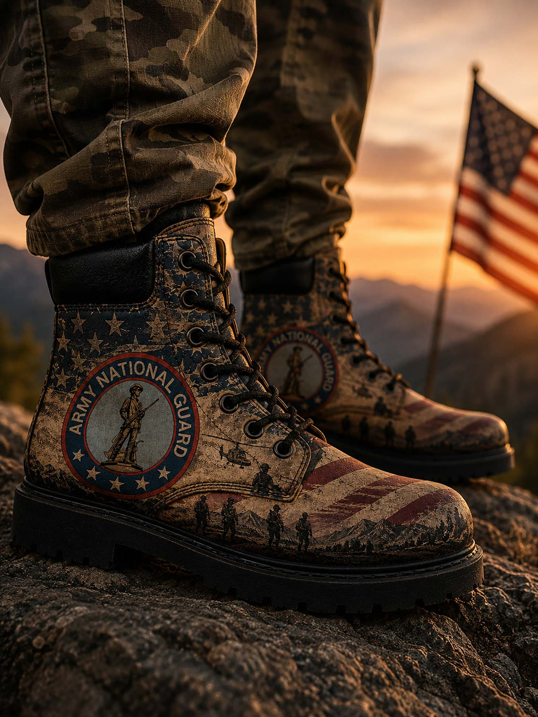 A pair of lace-up combat boots displayed inside an open cardboard shoebox with tissue paper, with a hand holding the front boot. The boots feature a distressed American flag and military theme with the 'Army National Guard' emblem on the side.