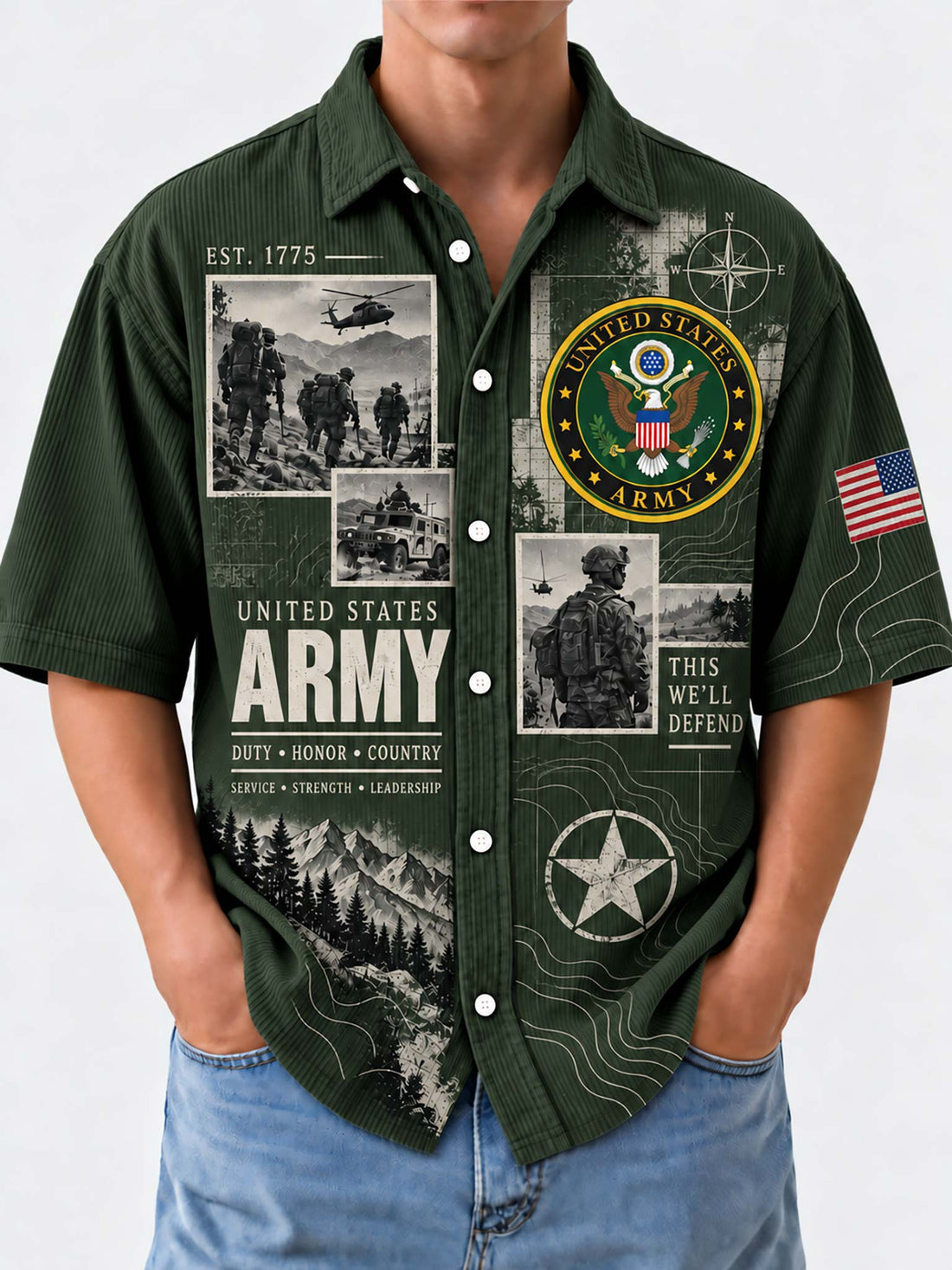 A man wearing a dark green short-sleeve button-up shirt with a detailed United States Army graphic print, paired with blue jeans, against a light gray background.