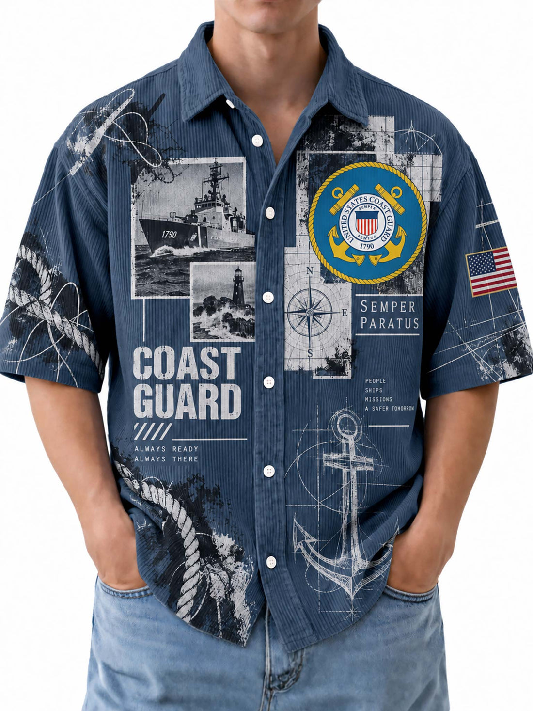 A man wearing a short-sleeve button-up shirt with a navy blue background and a detailed Coast Guard graphic print, paired with light blue jeans against a white studio background.