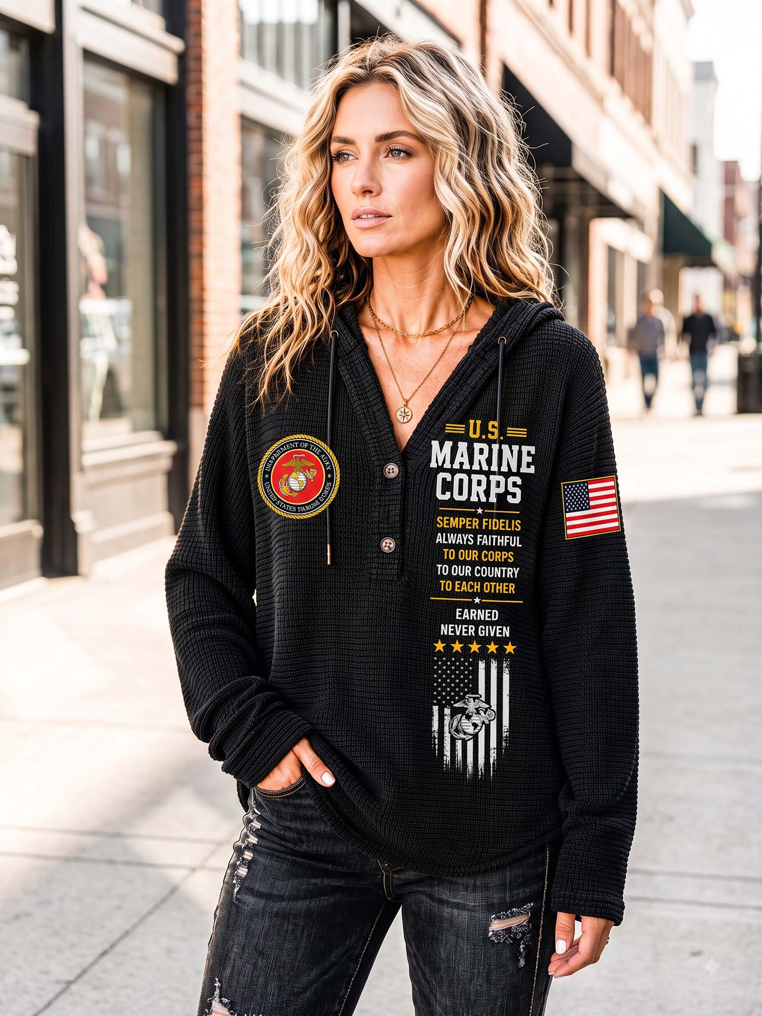 A woman stands on a city sidewalk wearing a black waffle-knit hoodie with U.S.