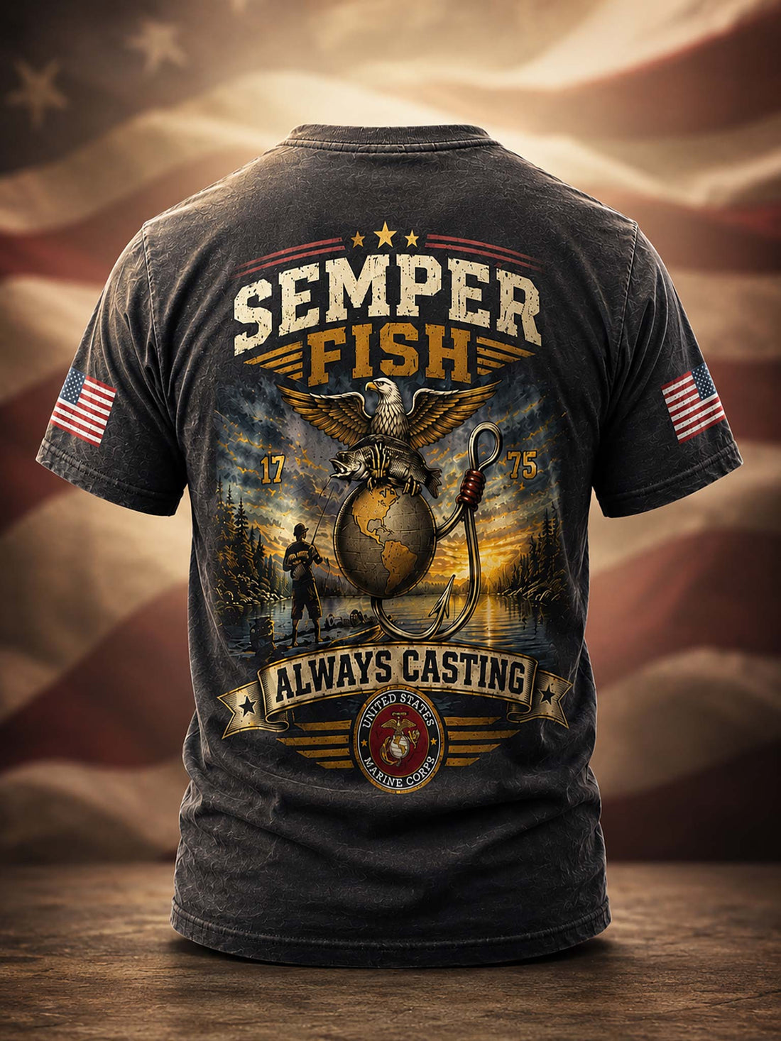 A dark charcoal gray graphic t-shirt shown from the back, featuring a large 'Semper Fish' design with an eagle, anchor, and globe motif, plus 'Always Casting' and a USMC emblem. The shirt is displayed on a wooden surface with a blurred American flag background.