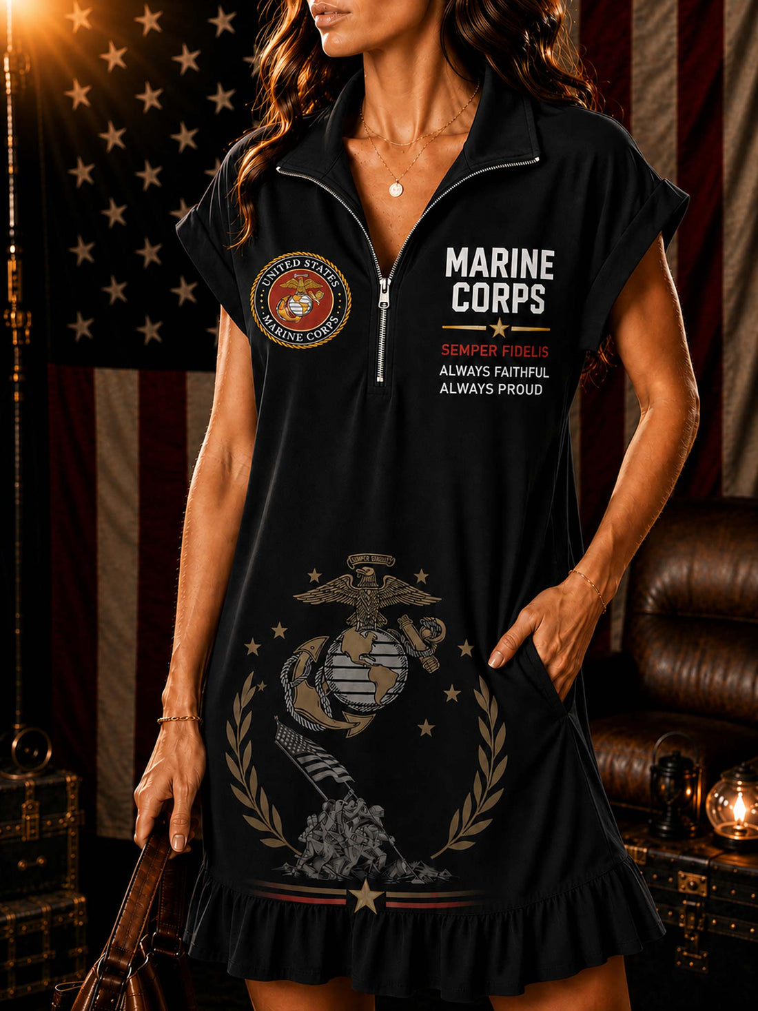 A woman models a white short-sleeve polo dress with a half-zip neckline, featuring 'MARINE CORPS' text, a Marine Corps emblem, and a large Marine Corps eagle, globe, and anchor insignia printed on the front. The background features a rustic American flag, leather furniture, and vintage suitcases.