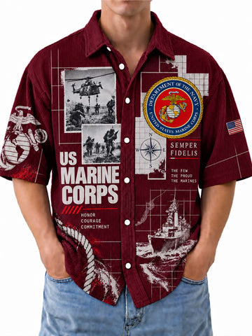 A man wearing a short-sleeve button-up shirt with a US Marine Corps themed graphic print. The shirt is maroon with white and black graphics, including the USMC emblem, 'US MARINE CORPS' text, and military-themed illustrations.