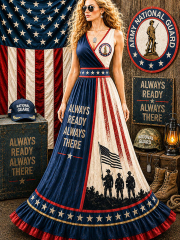 A woman models a patriotic Army National Guard themed maxi dress in a rustic themed setting with American flags, helmets, boots, and signboards. The dress features red, white, and blue vertical stripes with 'ALWAYS READY ALWAYS THERE' text and soldier silhouettes.