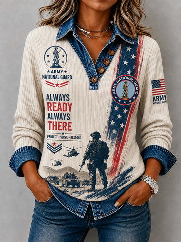 A woman wearing a long-sleeve button-front shirt with a cream ribbed body, blue denim collar and cuffs, and a patriotic military graphic featuring the words 'ALWAYS READY ALWAYS THERE' and 'ARMY NATIONAL GUARD' on a gray studio background.