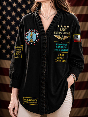 A woman wearing a black long-sleeve button-up shirt with military-themed patches and text, including 'Army National Guard' and 'Citizen Warrior' designs, posed against an American flag backdrop.