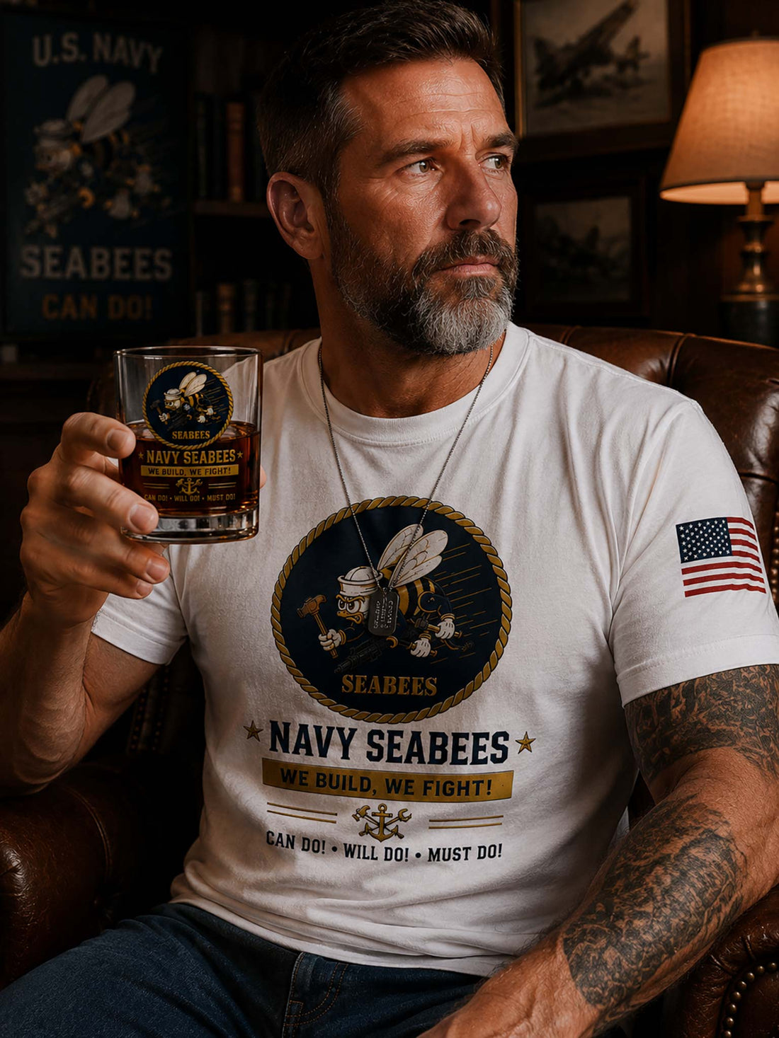 A clear glass tumbler with a navy blue and gold Seabees emblem and the text 'NAVY SEABEES' and 'WE BUILD, WE FIGHT!' shown filled with amber liquid against a black background.
