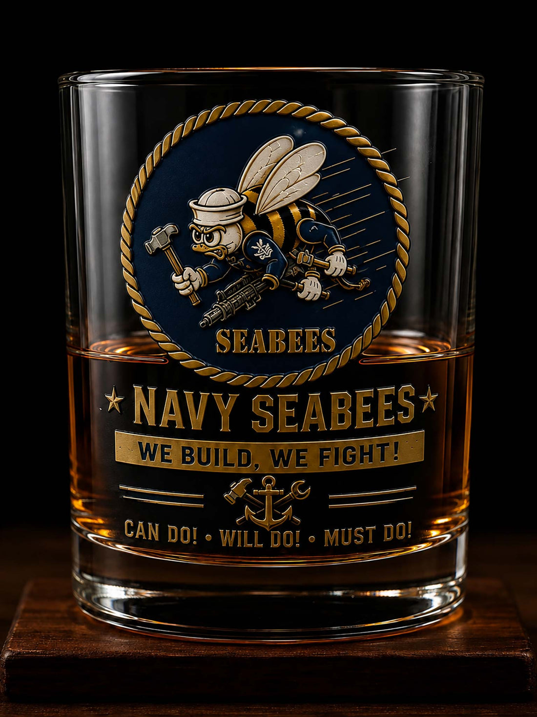 A clear glass tumbler with a navy blue and gold Seabees emblem and the text 'NAVY SEABEES' and 'WE BUILD, WE FIGHT!' shown filled with amber liquid against a black background.