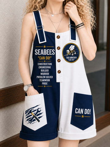 A woman wearing a navy blue and white Seabees-themed overall romper with 'CAN DO!' text and patches, standing against a neutral outdoor wall.