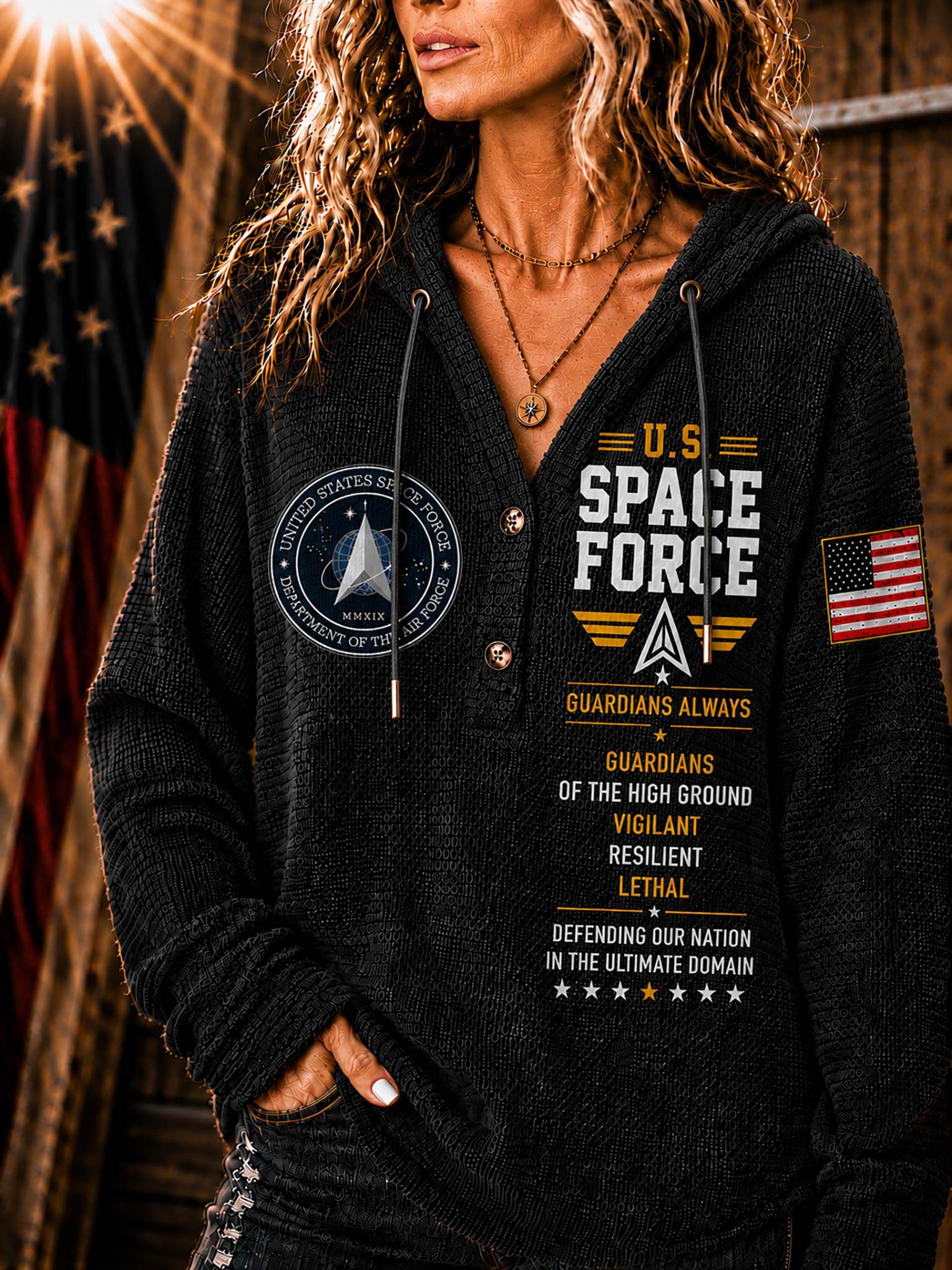 A woman wearing a black knit hoodie with military-themed graphics, including 'U.S.