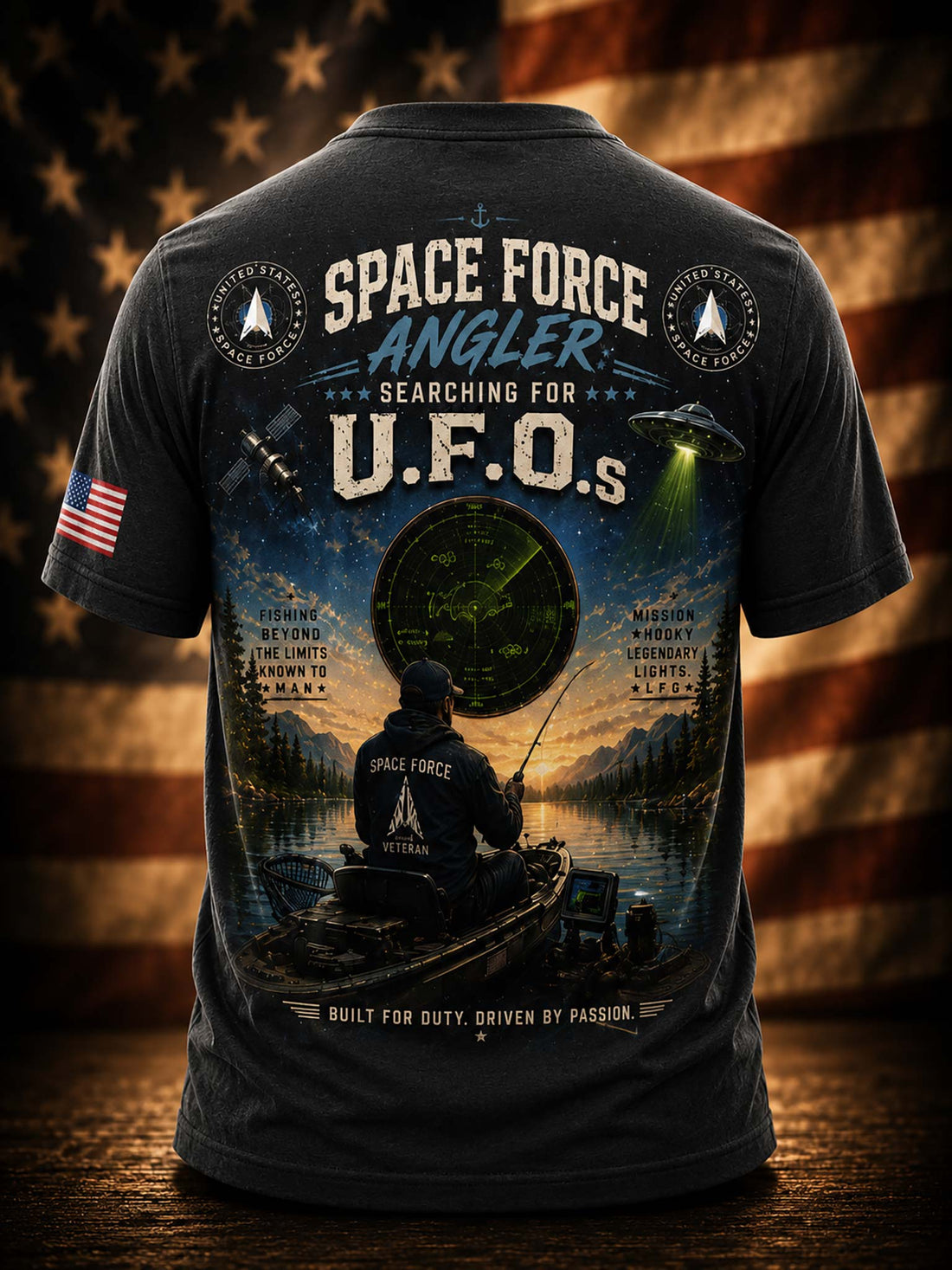 A black graphic t-shirt against a patriotic American flag and fishing scene background. 