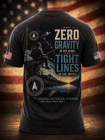 A black short-sleeve t-shirt shown from the back, featuring a large patriotic military-themed graphic with a fisherman silhouette, stars, mountains, and text reading 'ZERO GRAVITY IN MY MIND. TIGHT LINES IN THE WATER.