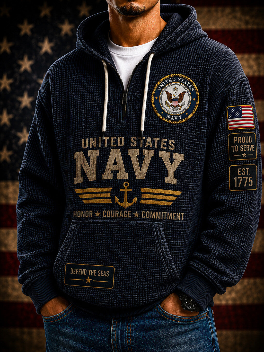 A navy blue pullover hoodie shown from both front and back, featuring large gold and beige 'United States Navy' text, an eagle emblem, anchor graphic, American flag patch, and 'Honor + Courage + Commitment' text. The hoodie is displayed against a dark background with spotlight effects and a blurred American flag.
