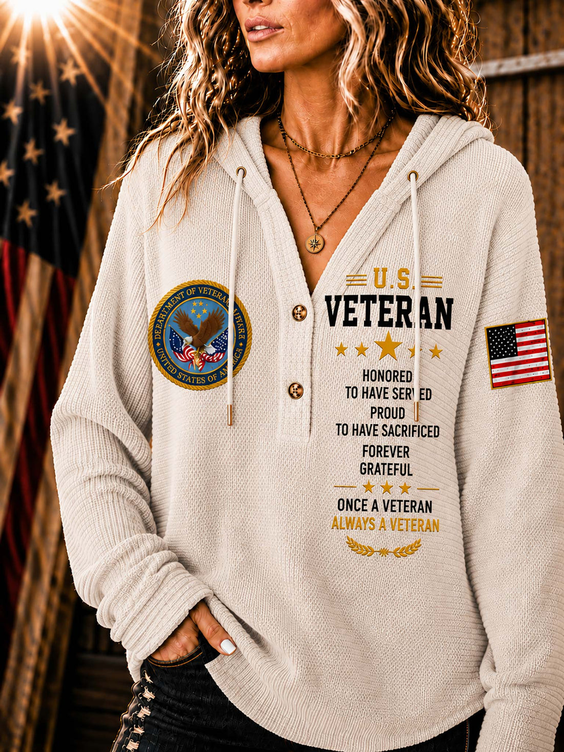 A woman wearing a cream-colored V-neck pullover hoodie with a 'U.S.