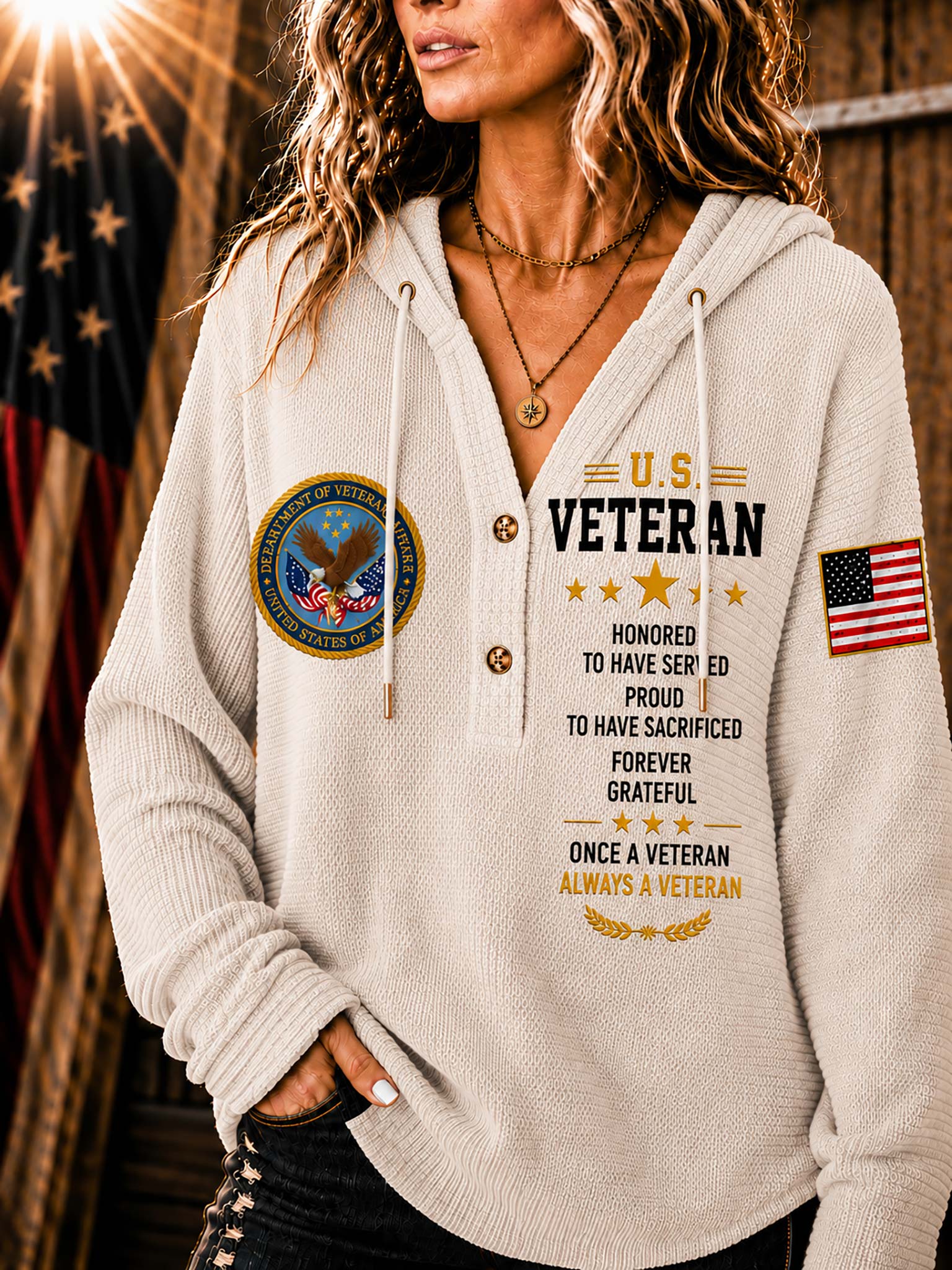 A woman wearing a cream-colored V-neck pullover hoodie with a 'U.S.