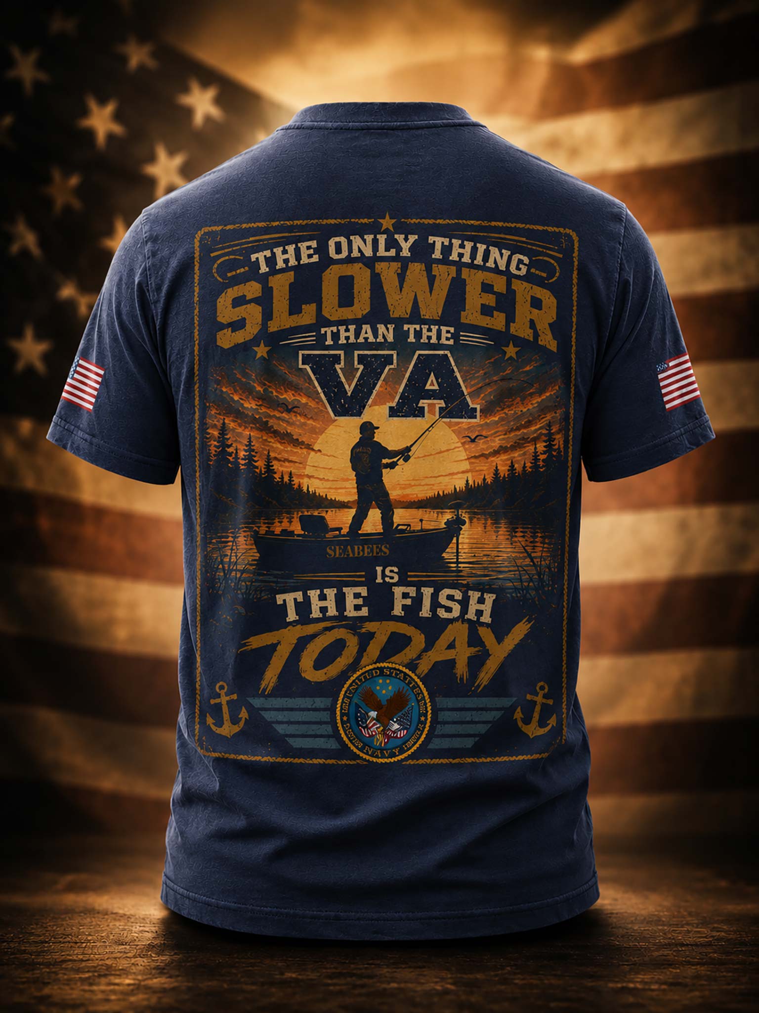 A navy blue short-sleeve t-shirt shown from the back, featuring a large fishing-themed graphic with the text 'THE ONLY THING SLOWER THAN THE VA IS THE FISH TODAY' and a sunset boat scene. Small American flag prints appear on both sleeves, and the shirt is displayed against a blurred American flag background.
