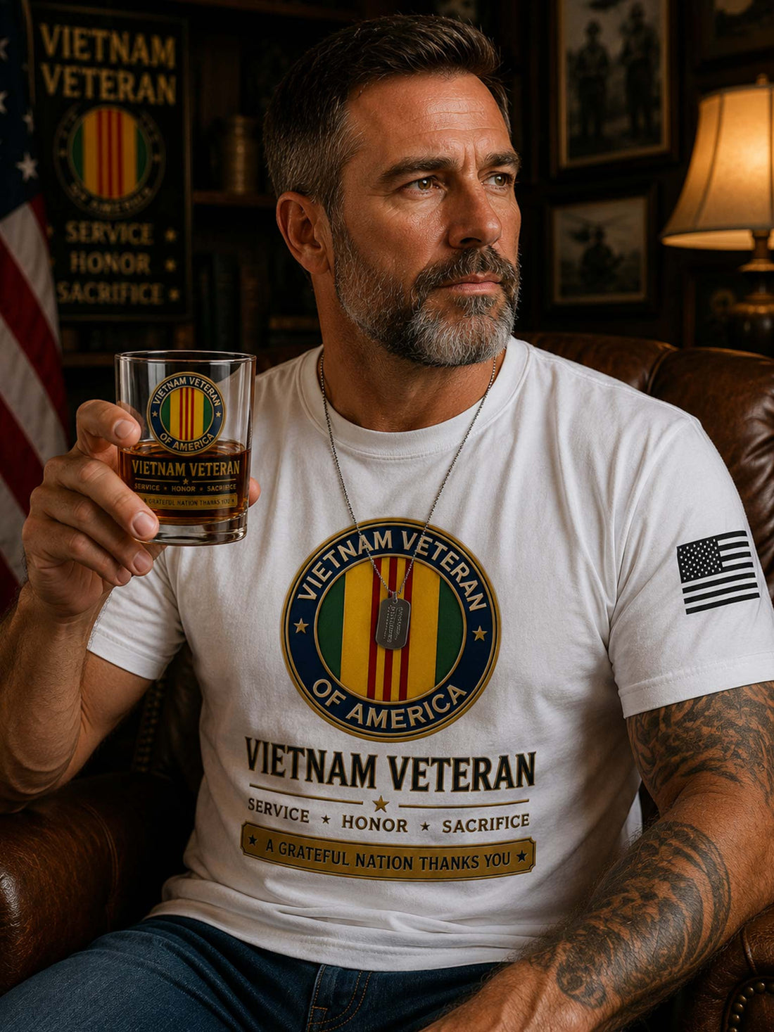 A clear whiskey tumbler with a Vietnam Veteran of America emblem and text printed on the front, filled with amber liquid and photographed against a black background.
