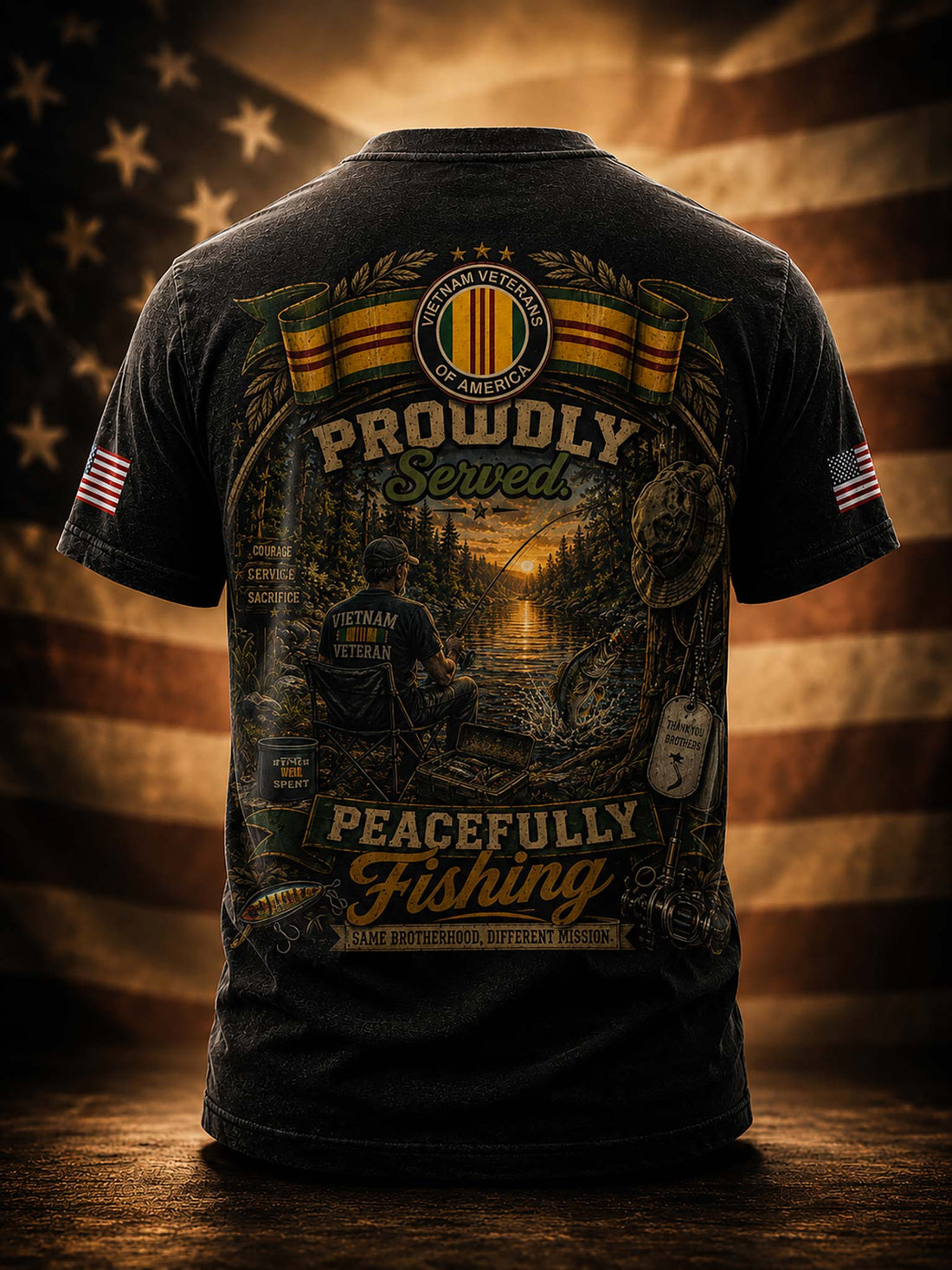 A black graphic t-shirt shown from the back, featuring a large military-themed fishing design with the text 'Proudly Served' and 'Peacefully Fishing,' plus American flag patches on both sleeves, set against a blurred American flag background.