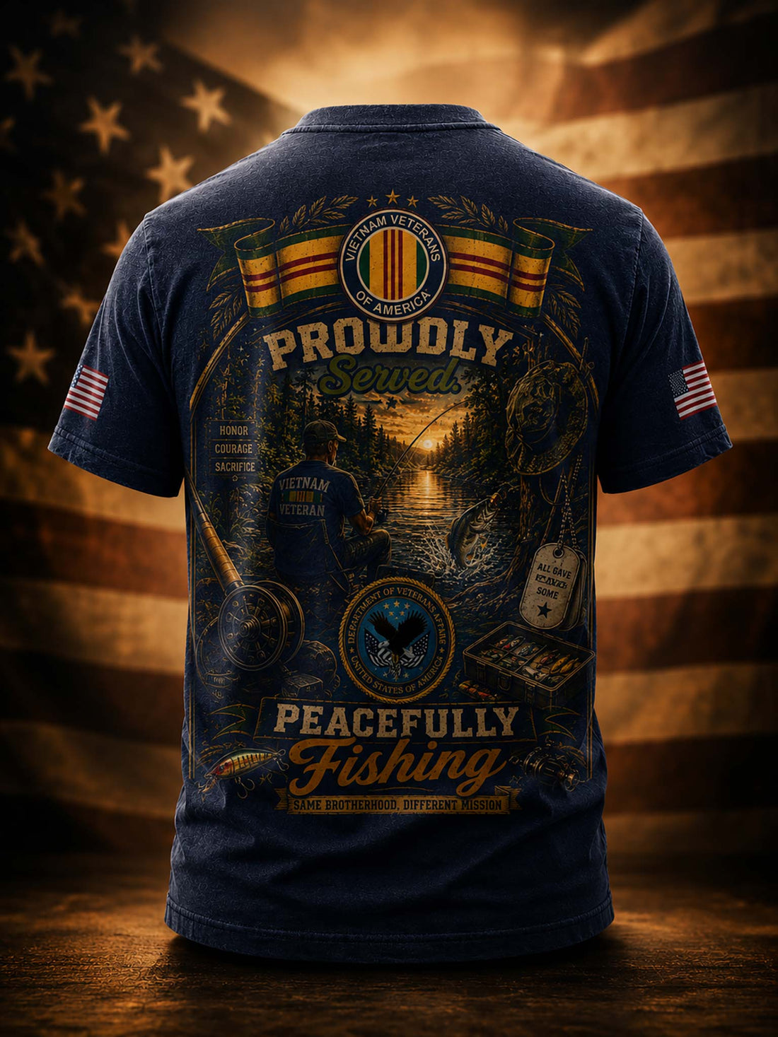 A black graphic t-shirt shown from the back, featuring a large military-themed fishing design with the text 'Proudly Served' and 'Peacefully Fishing,' plus American flag patches on both sleeves, set against a blurred American flag background.