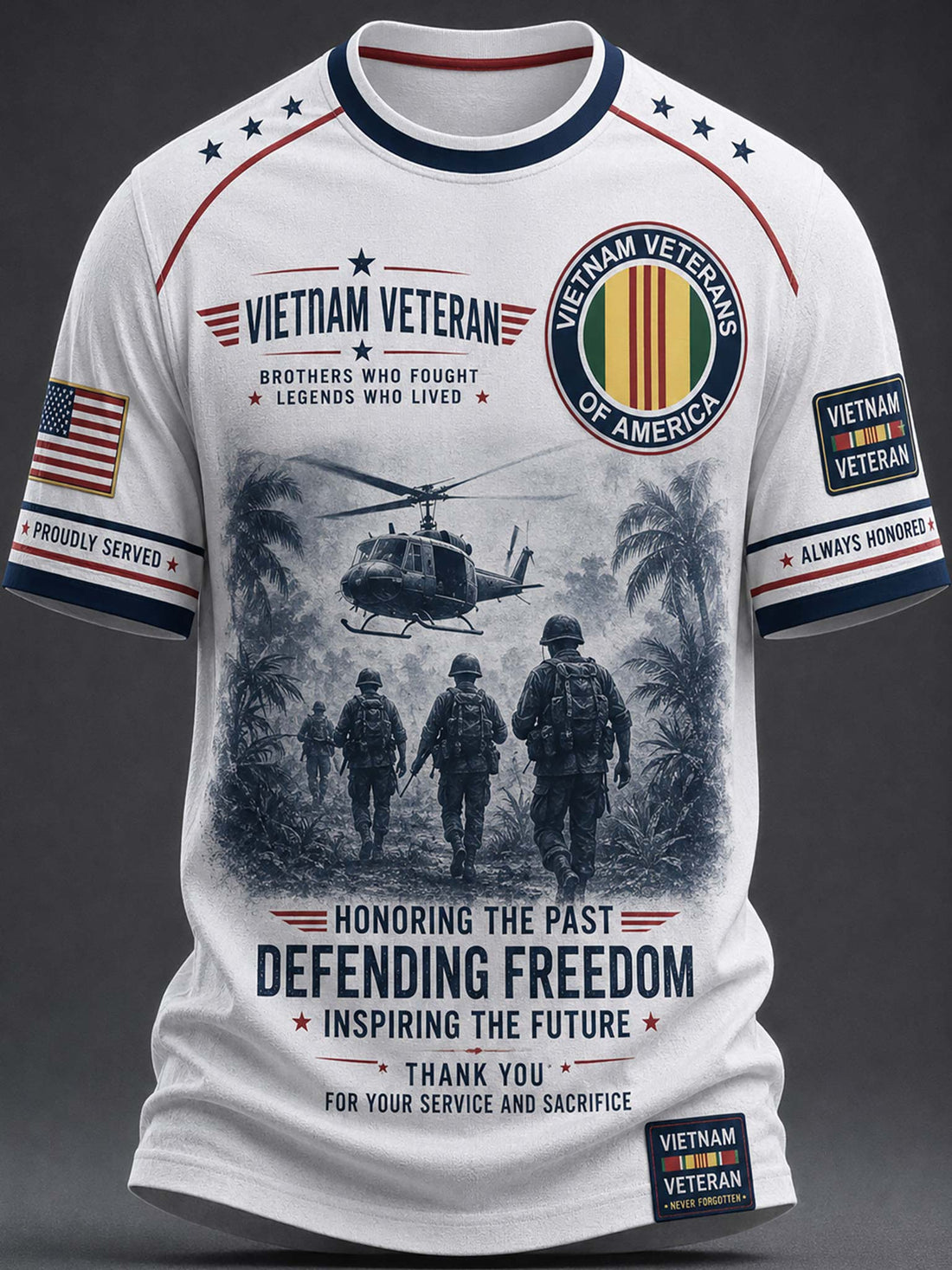 A white short-sleeve t-shirt with a detailed graphic print celebrating Vietnam Veterans. The design features a black-and-white illustration of soldiers and a helicopter, alongside patriotic red, white, and blue ribbons, stars, and text including 'VIETNAM VETERAN' and 'DEFENDING FREEDOM'.