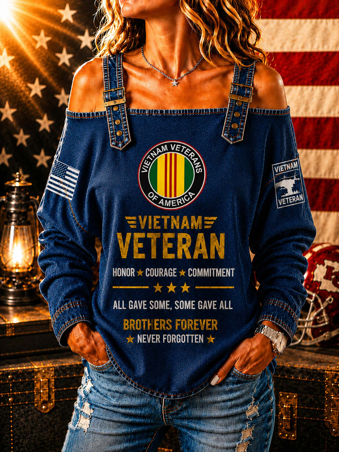 A woman wearing a light blue off-the-shoulder long-sleeve shirt with a distressed denim look. The shirt features a 'Vietnam Veteran of America' emblem on the chest, yellow text reading 'Vietnam Veteran' and 'All gave some, some gave all, brothers forever never forgotten', a small American flag on one sleeve, and a 'Vietnam Veteran' patch on the other sleeve.