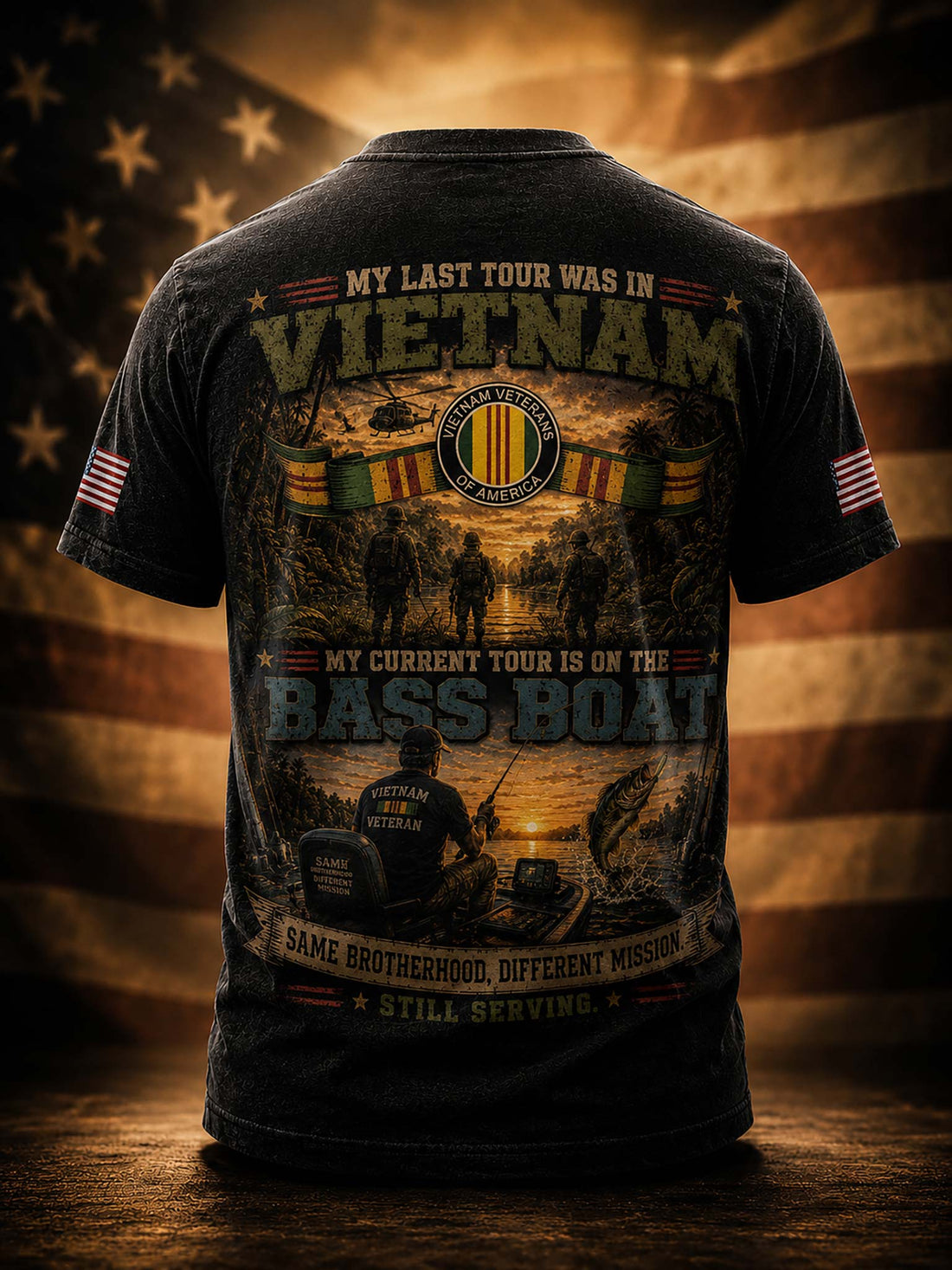 A black graphic t-shirt shown from the back, featuring a detailed military-themed print with text about Vietnam and the Bass Boat, set against a blurred American flag background.