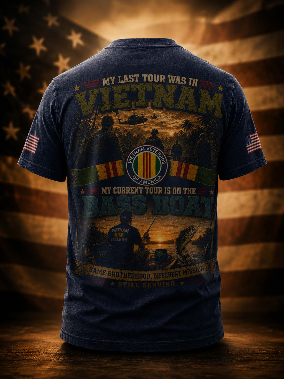 A black graphic t-shirt shown from the back, featuring a detailed military-themed print with text about Vietnam and the Bass Boat, set against a blurred American flag background.
