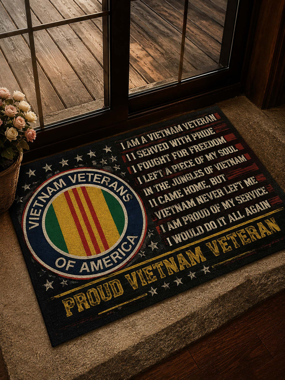 A rectangular doormat with a Vietnam Veterans design, placed on a stone step in front of a glass door. The mat features the Vietnam Veterans emblem on the left and a printed patriotic quote on the right, with 'PROUD VIETNAM VETERAN' written at the bottom.