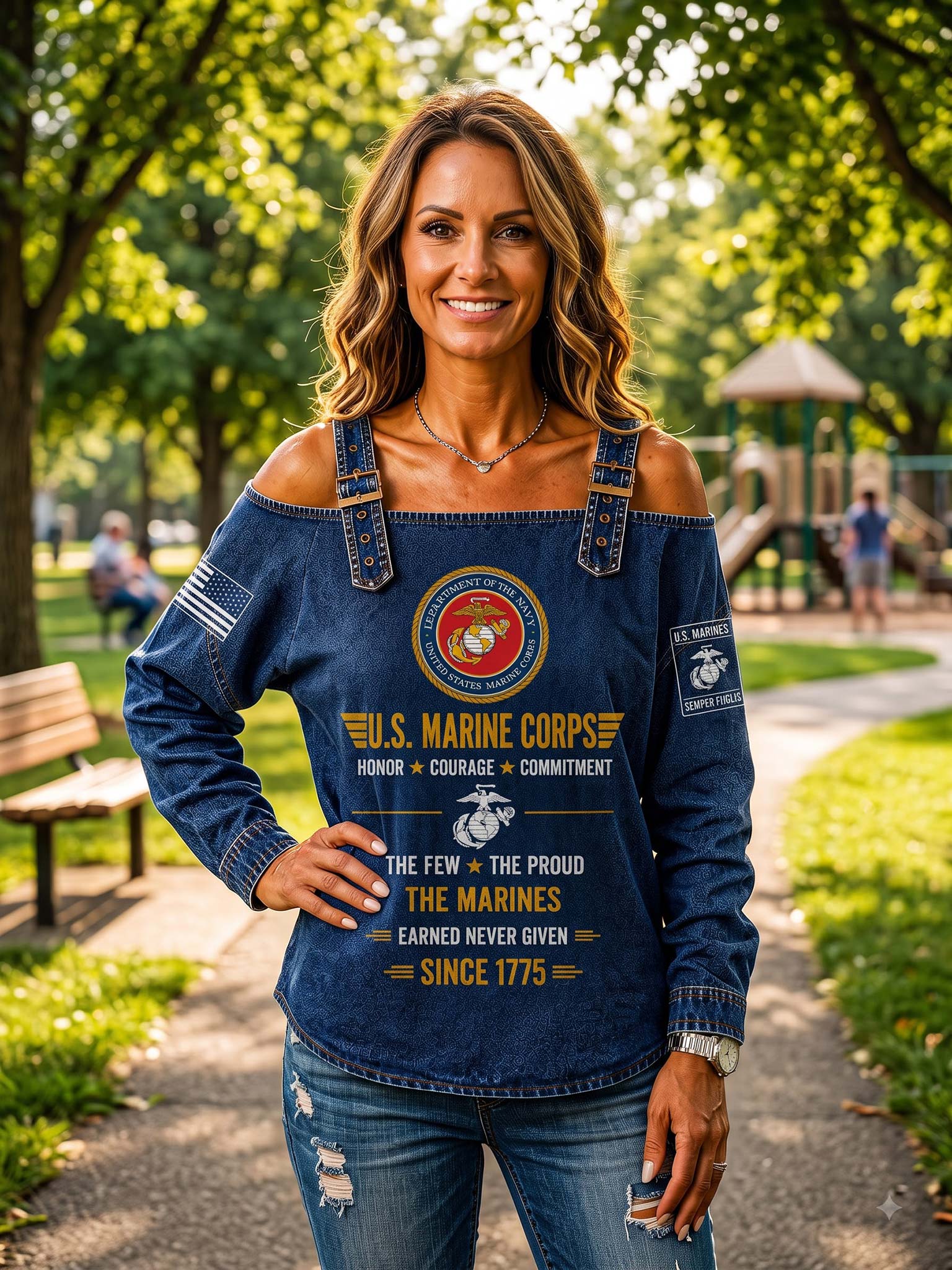 A woman standing in a sunny park wearing a dark blue denim off-the-shoulder top with a U.S.