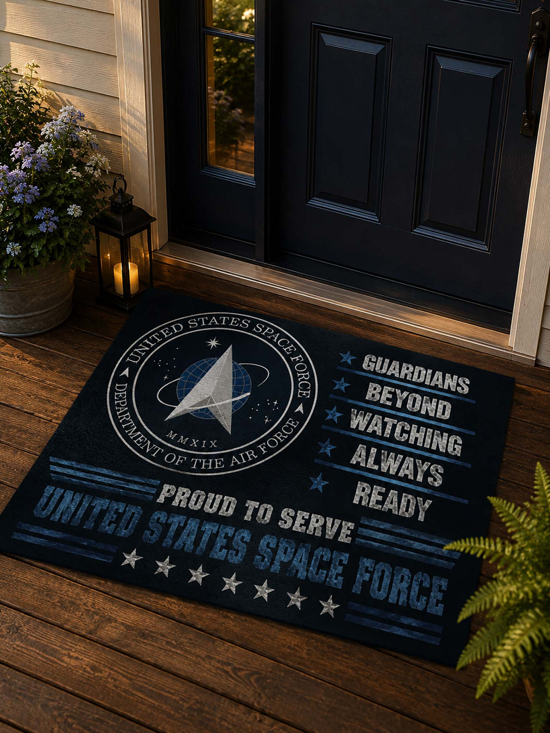 A rectangular doormat with a United States Space Force design, placed on a tan stone or concrete step in front of glass doors. The mat is dark navy with white and light blue text and graphics, including the Space Force emblem and the words 'Guardians Beyond Watching Always Ready' and 'Proud to Serve United States Space Force.
